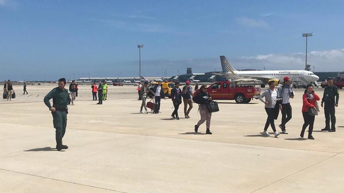 Los pasajeros del avión de la compañía Vueling que ha aterrizado de emergencia en el aeropuerto de Barcelona por una falsa amenaza de bomba.