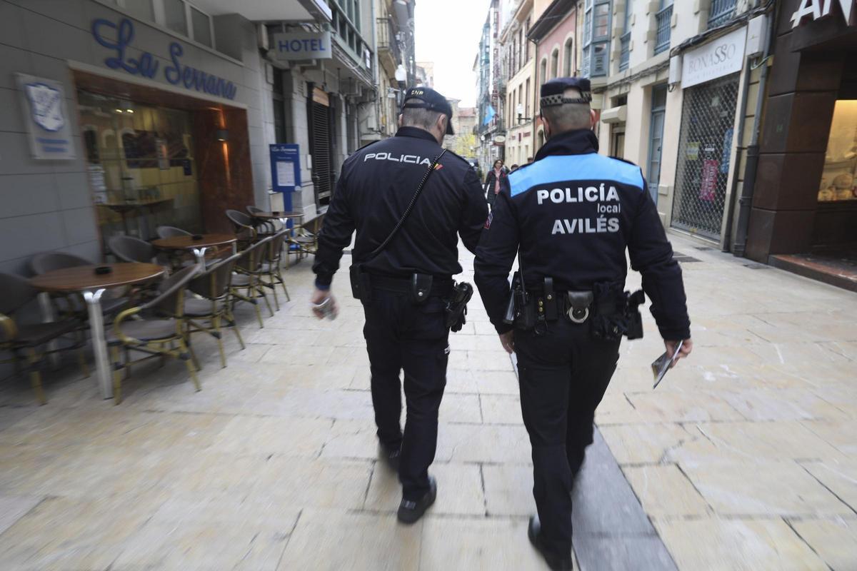 Dos policías, uno de la Nacional y otro de la Local, caminan por la calle La Fruta.