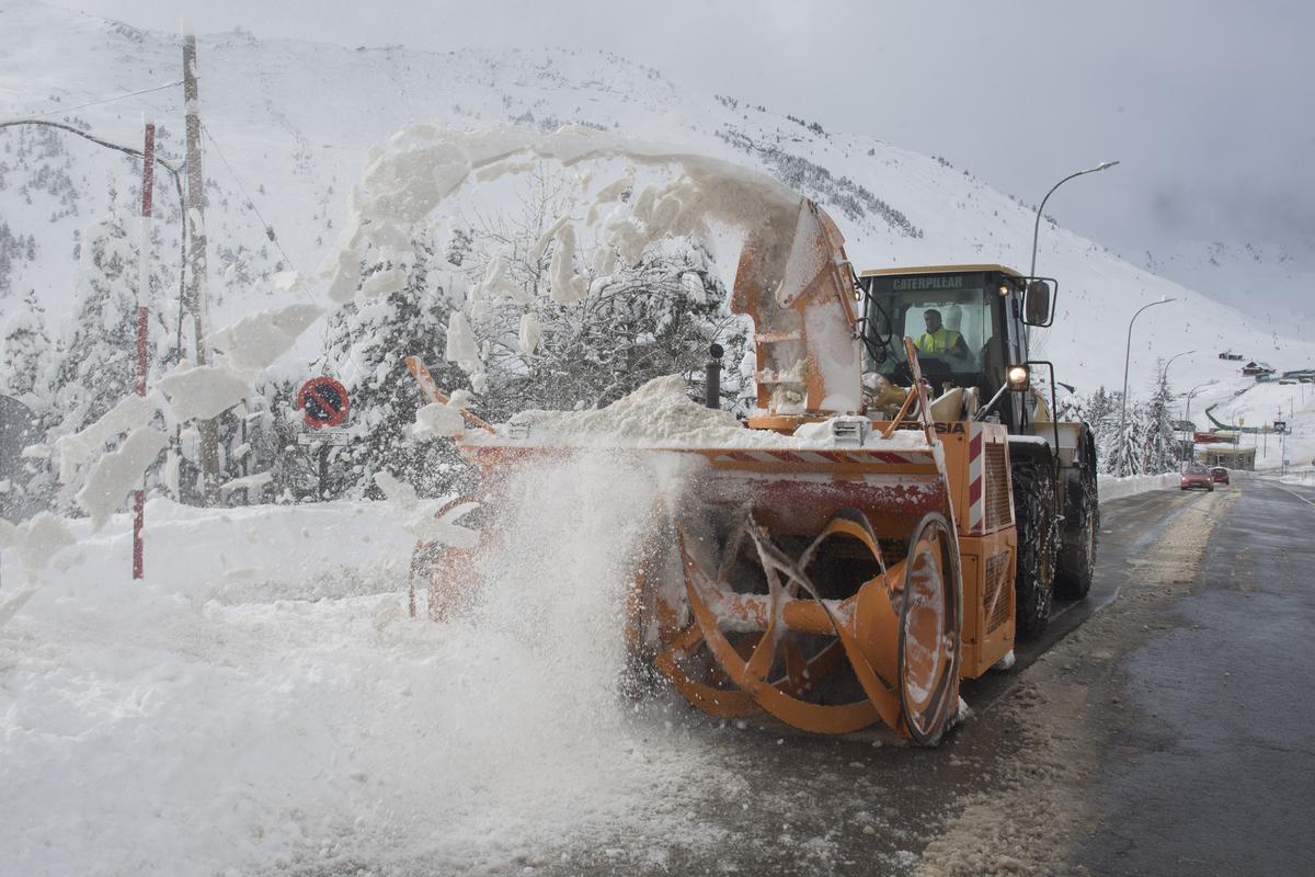 HUESCA, 18/01/2023.- Una máquina limpia la calzada de la nieve acumulada en Candanchú. El primer gran temporal del invierno en España, por el paso de la borrasca Fien, ha cubierto hoy de nieve la mitad norte peninsular, lo que dificulta el tráfico en más de un centenar de carreteras, especialmente el de camiones, varias vías se han visto afectadas por inundaciones y se han suspendido rutas escolares en varias comunidades. EFE/ Javier Blasco