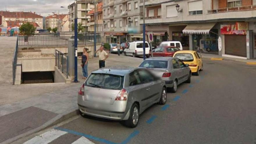 Dos personas retiran tique de estacionamiento en zona azul en el centro de Ponteareas. // FdV
