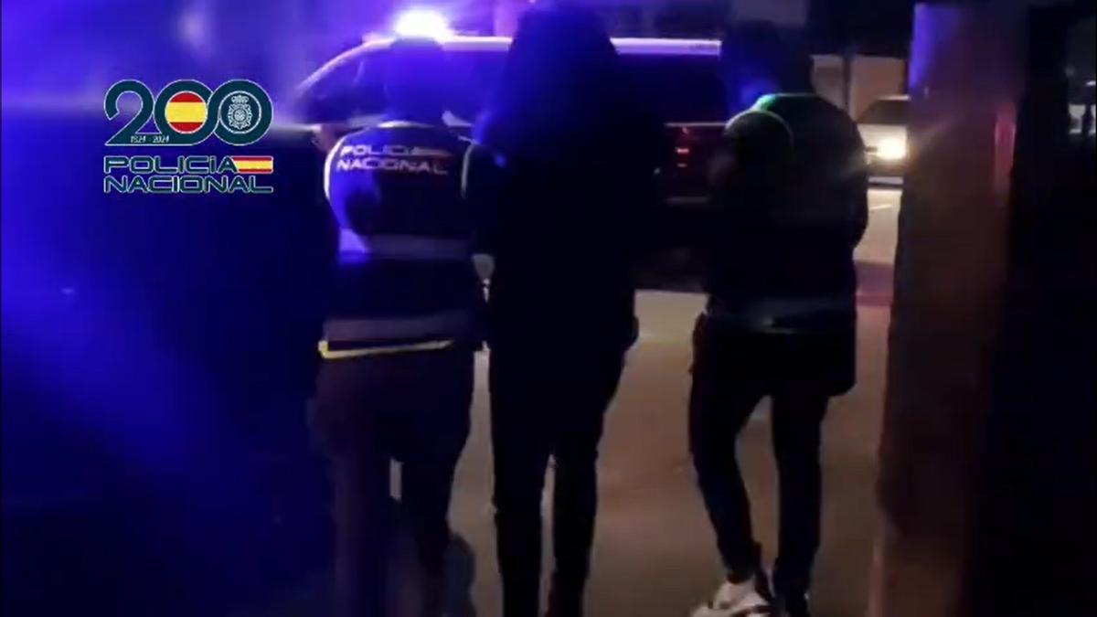 Dos policías escoltan al presunto yihadista, después de su detención, en Ribadumia.