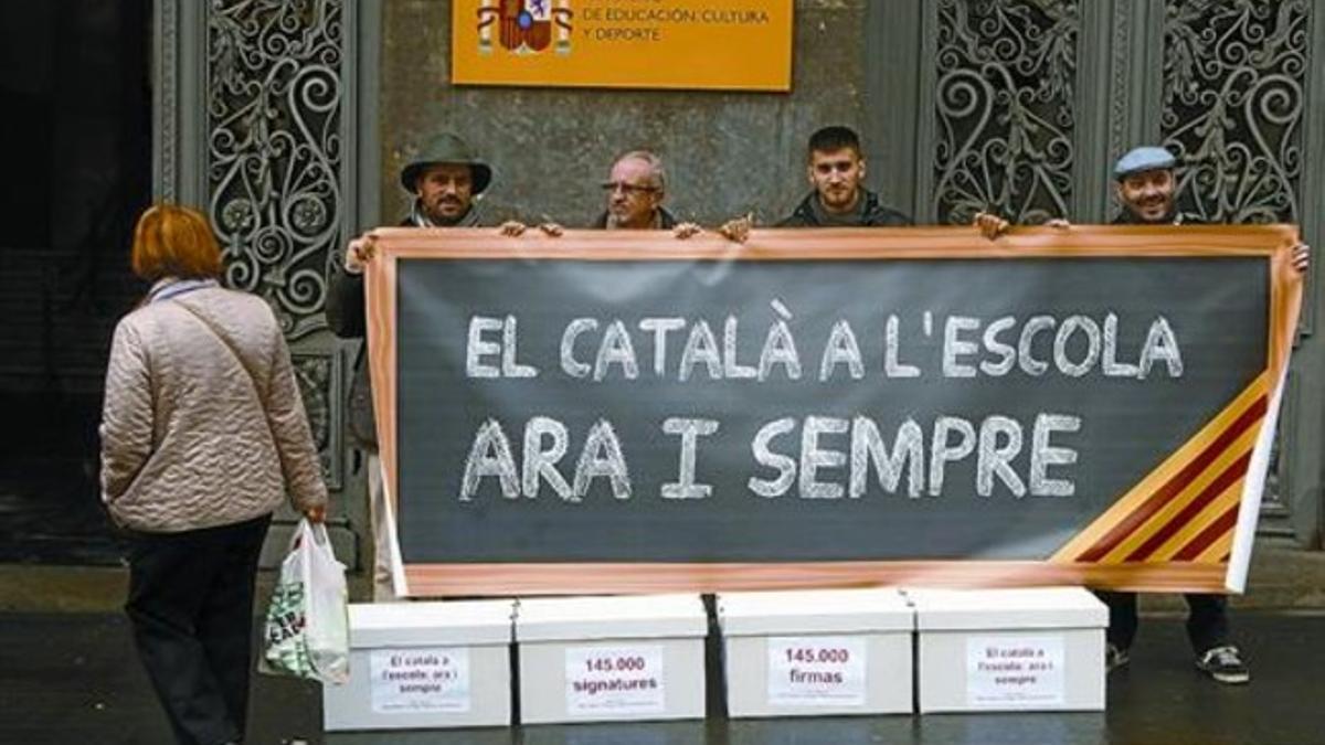 Pancarta a favor del catalán desplegada ayer ante el ministerio, antes de la entrega de 144.000 firmas.