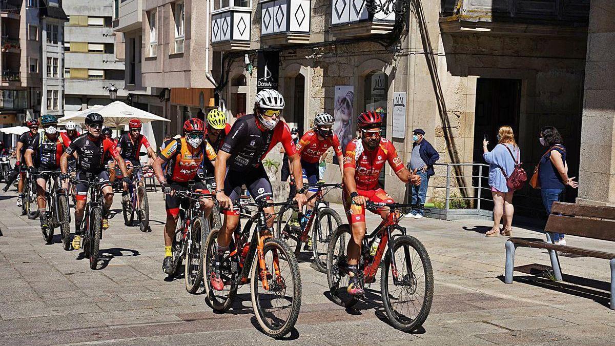 Ciclistas del equipo #InvestigaciónEsVida, ayer en la Praza de la Igrexa de Lalín, con Sergio Pazos.