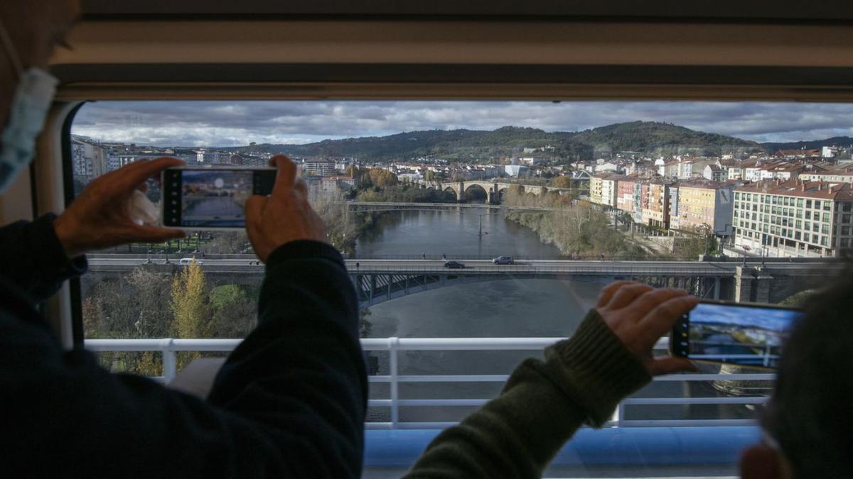 Pasajeros del AVE fotografiando el río Miño y los puentes de la capital ourensana. |   // BRAIS LORENZO