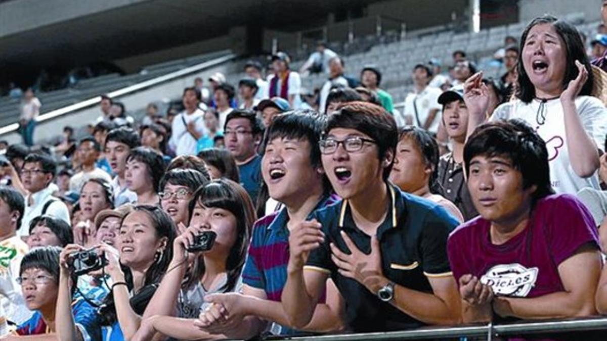Los aficionados coreanos siguen el entrenamiento del Barça, ayer.