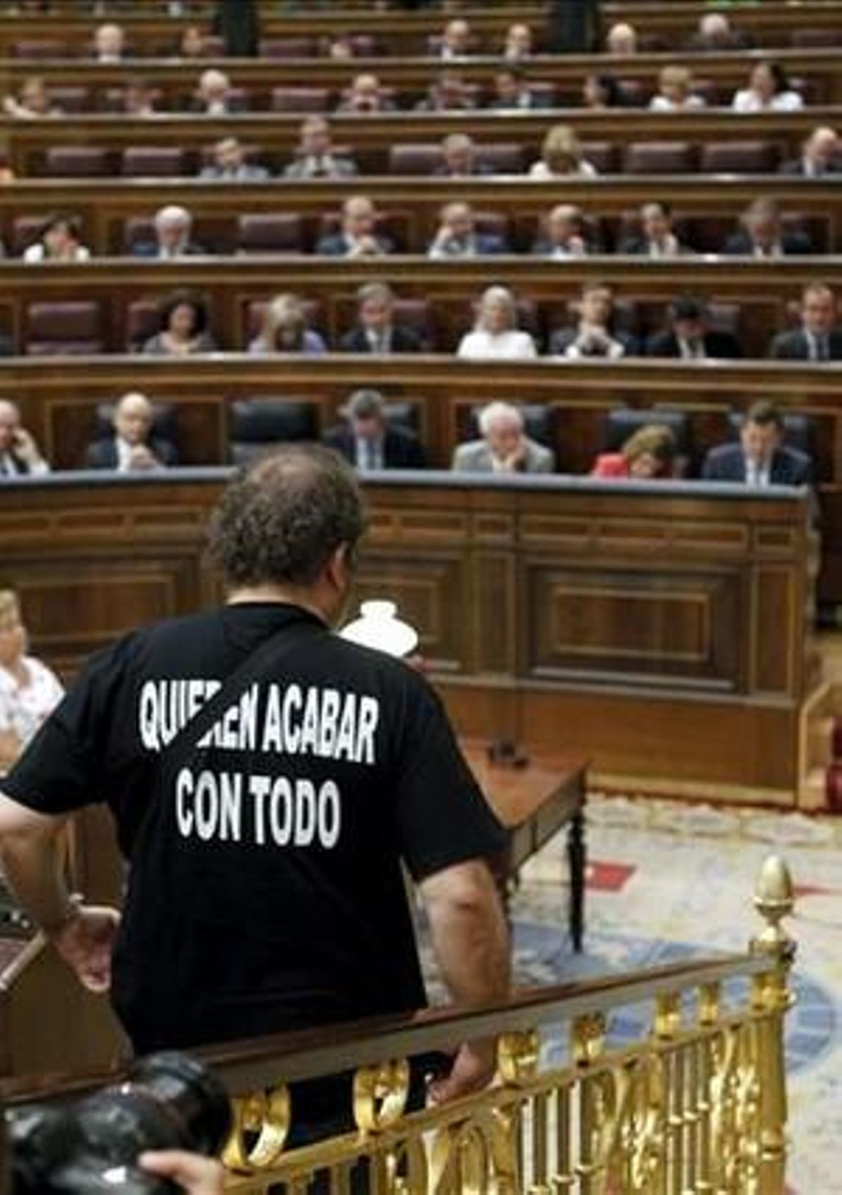 Chesús Yuste, diputat d’Esquerra Plural, abandona l’hemicicle, durant el ple del Congrés. Al fons, Mariano Rajoy.