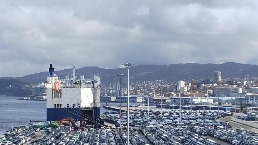 Un buque atracado ayer en una explanada portuaria repleta de vehículos