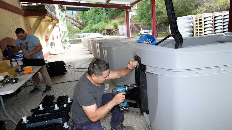 Los operarios dan los últimos retoques a los contenedores que serán instalados en el concejo.