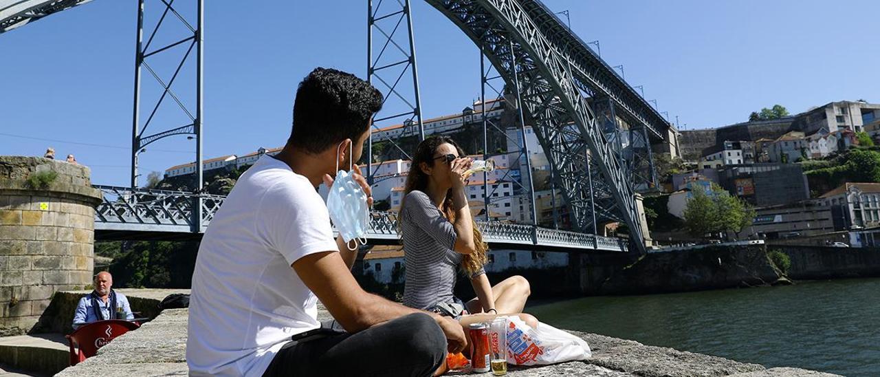 Dos jóvenes disfrutan del sol en Oporto