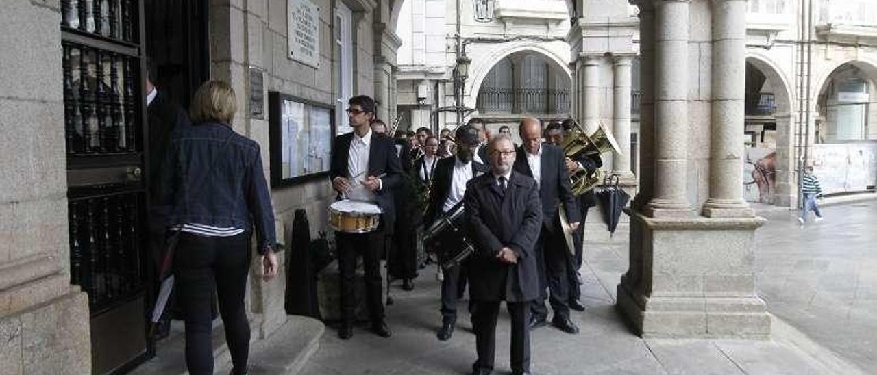 Varios músicos con sus instrumentos en la entrada del concello. // J. R.