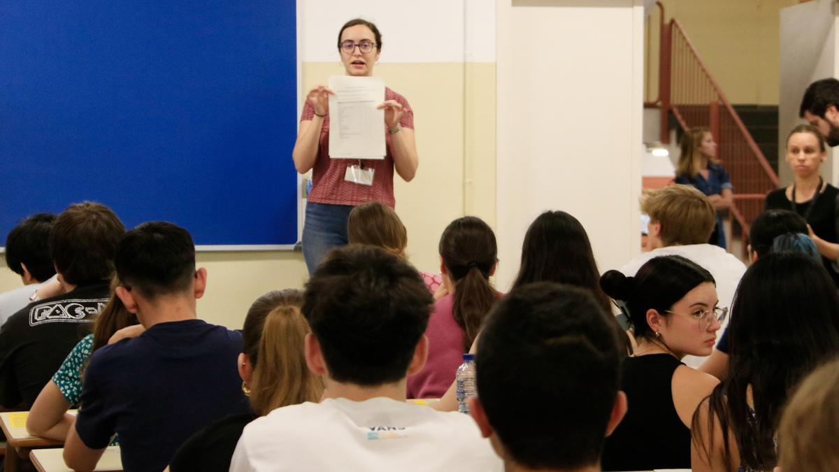 Estudiants a punt de començar la selectivitat escolten les instruccions de la supervisora pel que fa al formulari per escollir la llengua dels enunciats en català o castellà, en una aula de la Facultat de Biologia de la UB