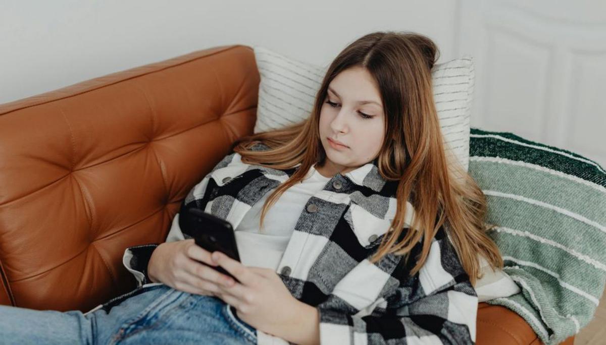 Una joven mirando su teléfono móvil. | Karolina Kaboompics