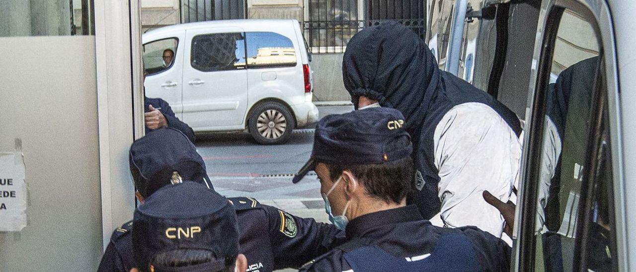 El acusado, al salir del furgón policial con la cara tapada al llegar a la Audiencia de Alicante.