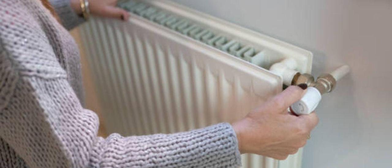 Una persona manipula un calefactor en un domicilio.