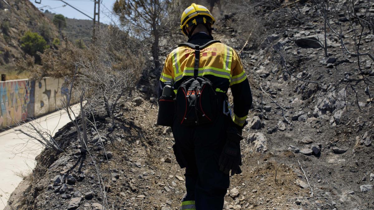 Un bombero recorre terreno quemado por el incendio de Portbou.