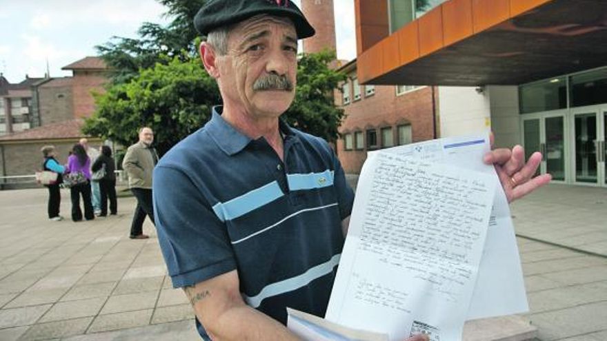 Tomás García, ayer, en la plaza de Europa de Piedras Blancas, con la reclamación y la contestación del Sespa.