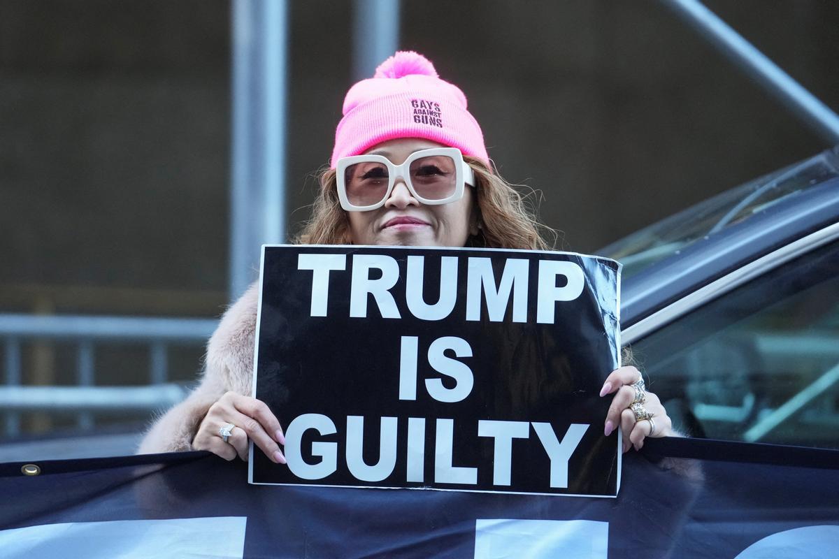 Una manifestante anti-Trump sostiene un cartel frente al Tribunal Penal de Manhattan después de que un gran jurado de Manhattan acusara al expresidente de los Estados Unidos, Donald Trump.