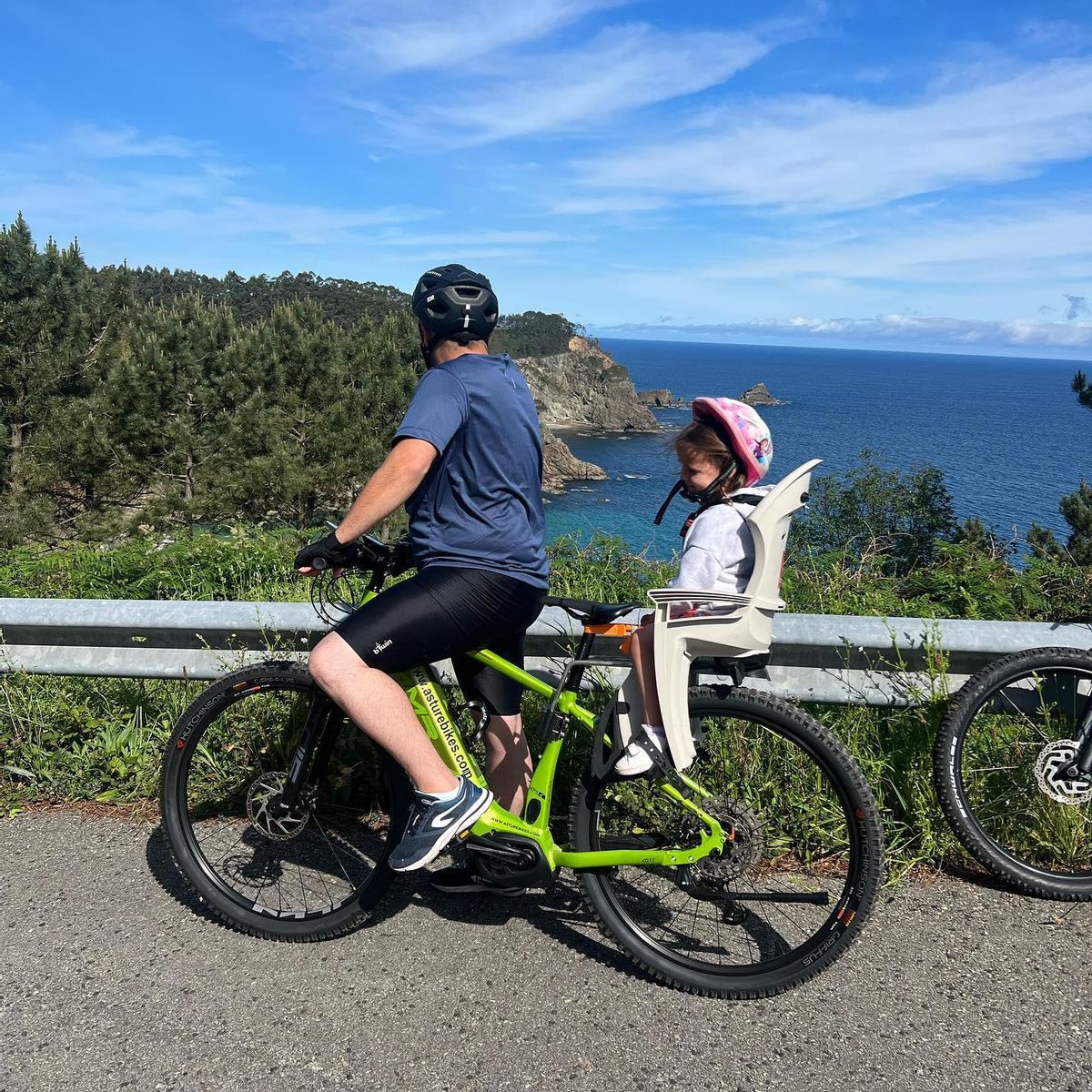 Padre e hija en bici eléctrica por la costa asturiana
