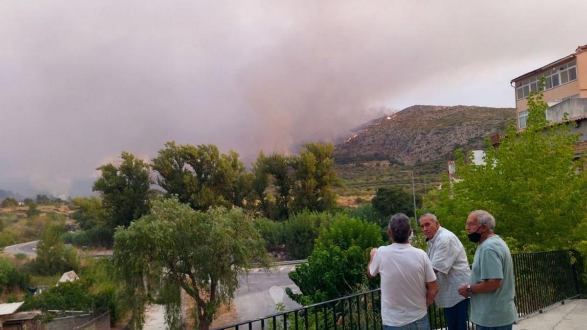 Varios vecinos ven desde las calles de la Vall d’Ebo el avance de las llamas a su alrededor.  | ALFONS PADILLA