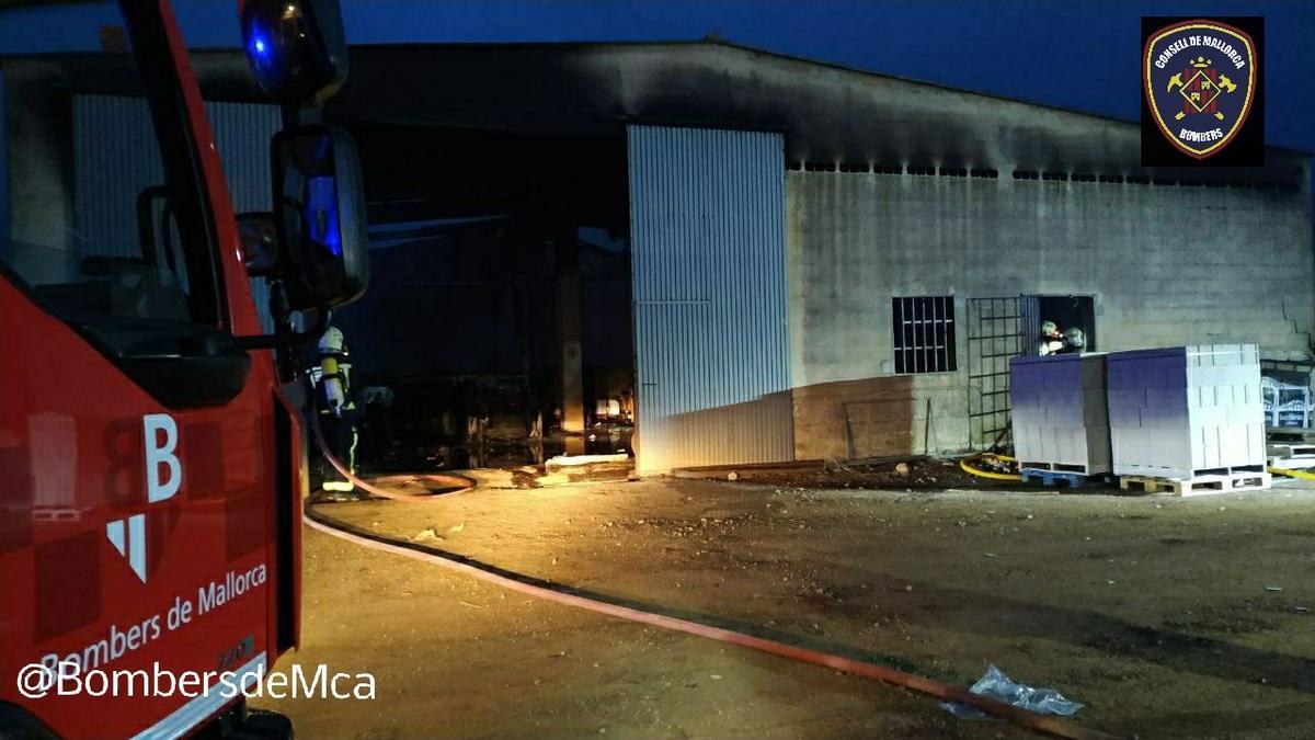 Los bomberos, durante la extinción del incendio en la nave de Selva.