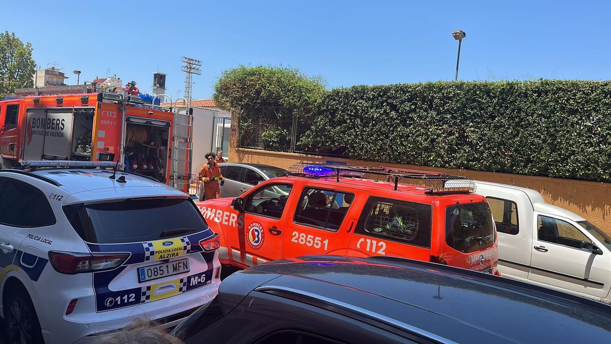 Vehículos de los bomberos y de la Policía Local ante la puerta de la piscina.