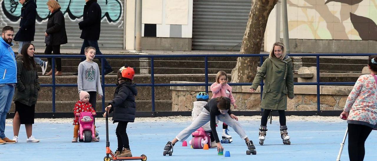 Niños disfrutan con sus juguetes en la pista de patinaje de Samil.