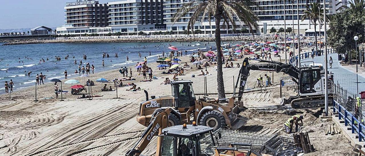 Operarios municipales procedieron ayer a cribar la arena ya limpia de hidrocarburos en la playa del Postiguet, que abre hoy tras cinco semanas acotada al 70%.