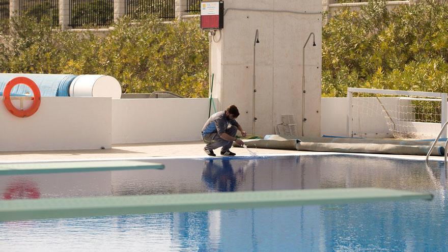 Un operario toma muestras del agua de la piscina de Torremolinos.
