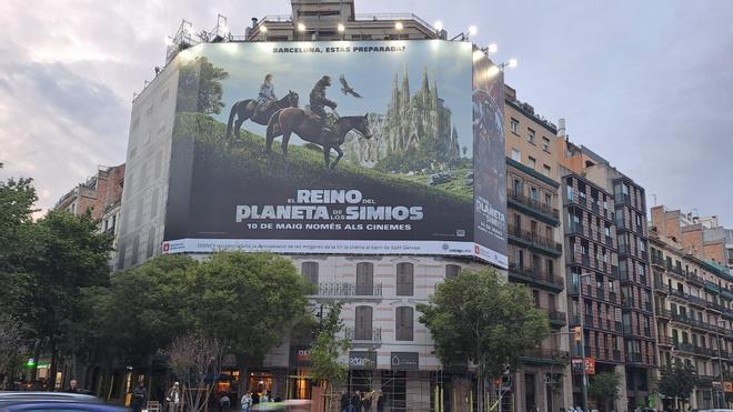 Cartel en la calle Aragó de la nueva película del planeta de los simios con la Sagrada Família de fondo.