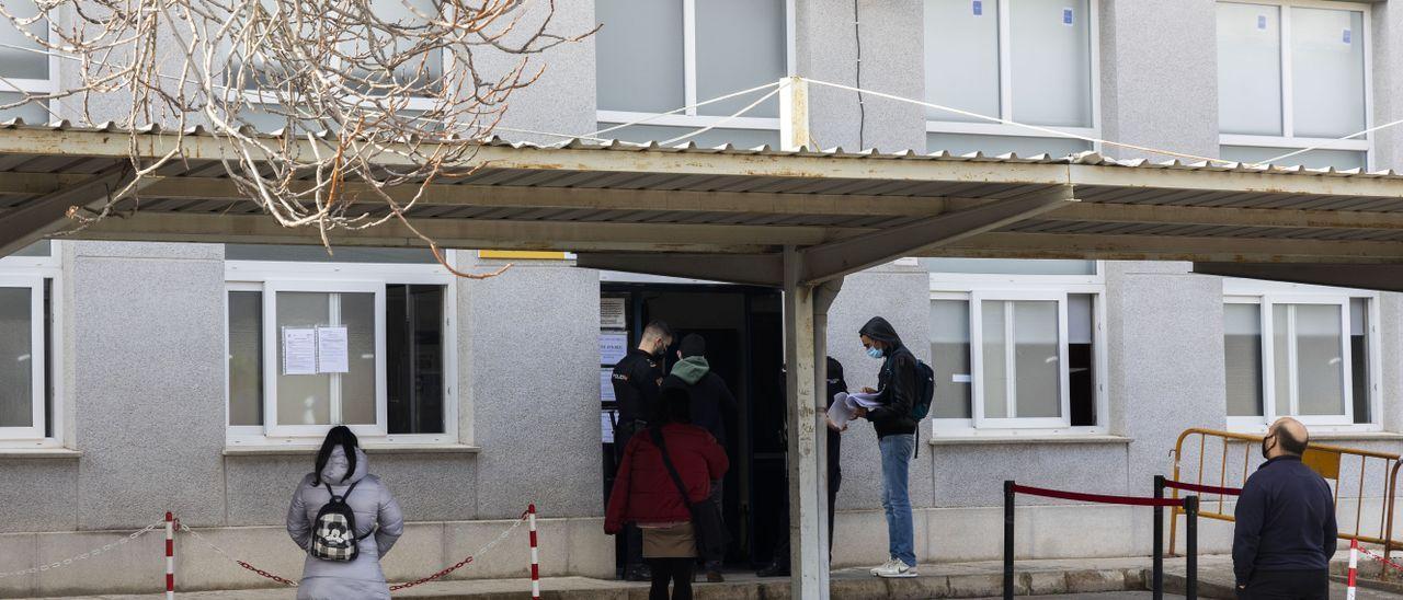 Migrantes esperan a resolver su documentación a las puertas de la comisaría de Vara de Quart, en València