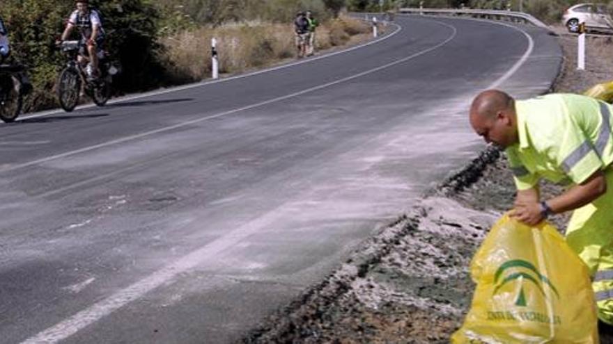 Un empleado de conservación de carreteras limpia los últimos restos del lugar del accidente