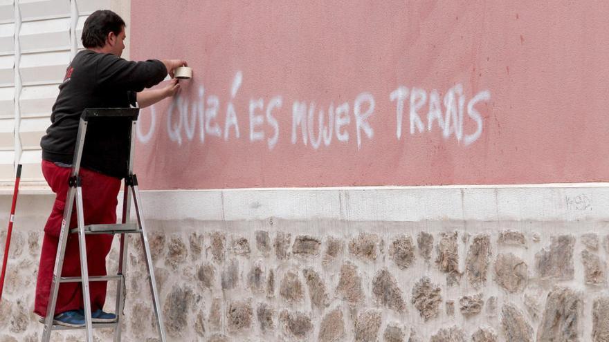 Un operario trabaja para retirar la pintada de la fachada.