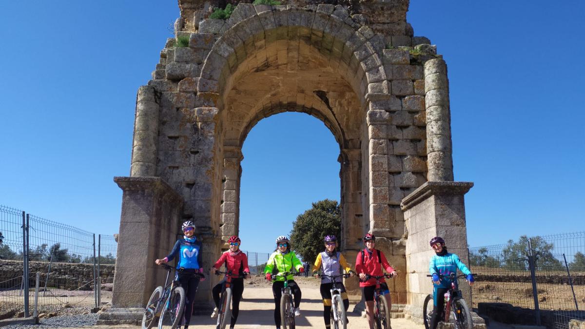 Margarita Tomé (izquierda), con participantes en una quedada, ante el arco de Cáparra.