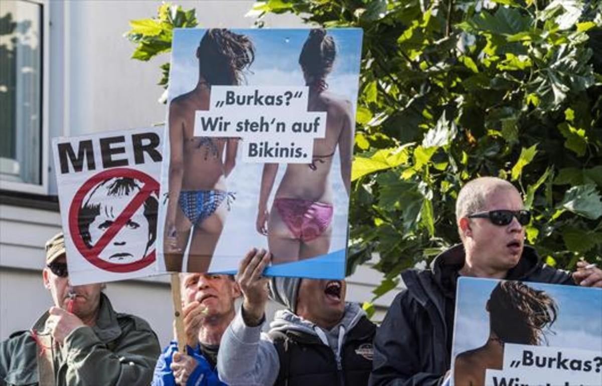 Radicales de la ultraderechista AfD exhiben pancartas contra Angela Merkel y el islam en Ostseebad Bliz, al norte de Alemania. Radicales de la ultraderechista AfD exhiben pancartas contra Angela Merkel y el islam en Ostseebad Bliz, al norte de Alemania.