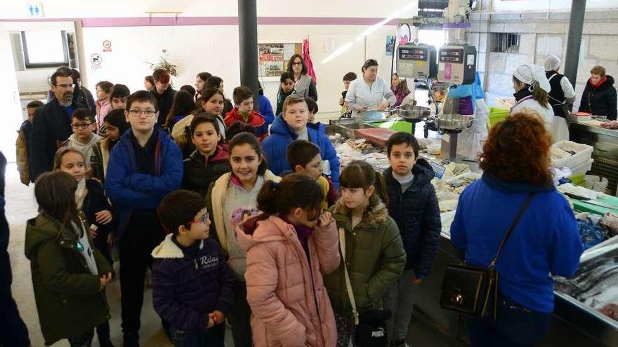 La comitiva de estudiantes, en el recorrido por la plaza de abastos. // G.Núñez