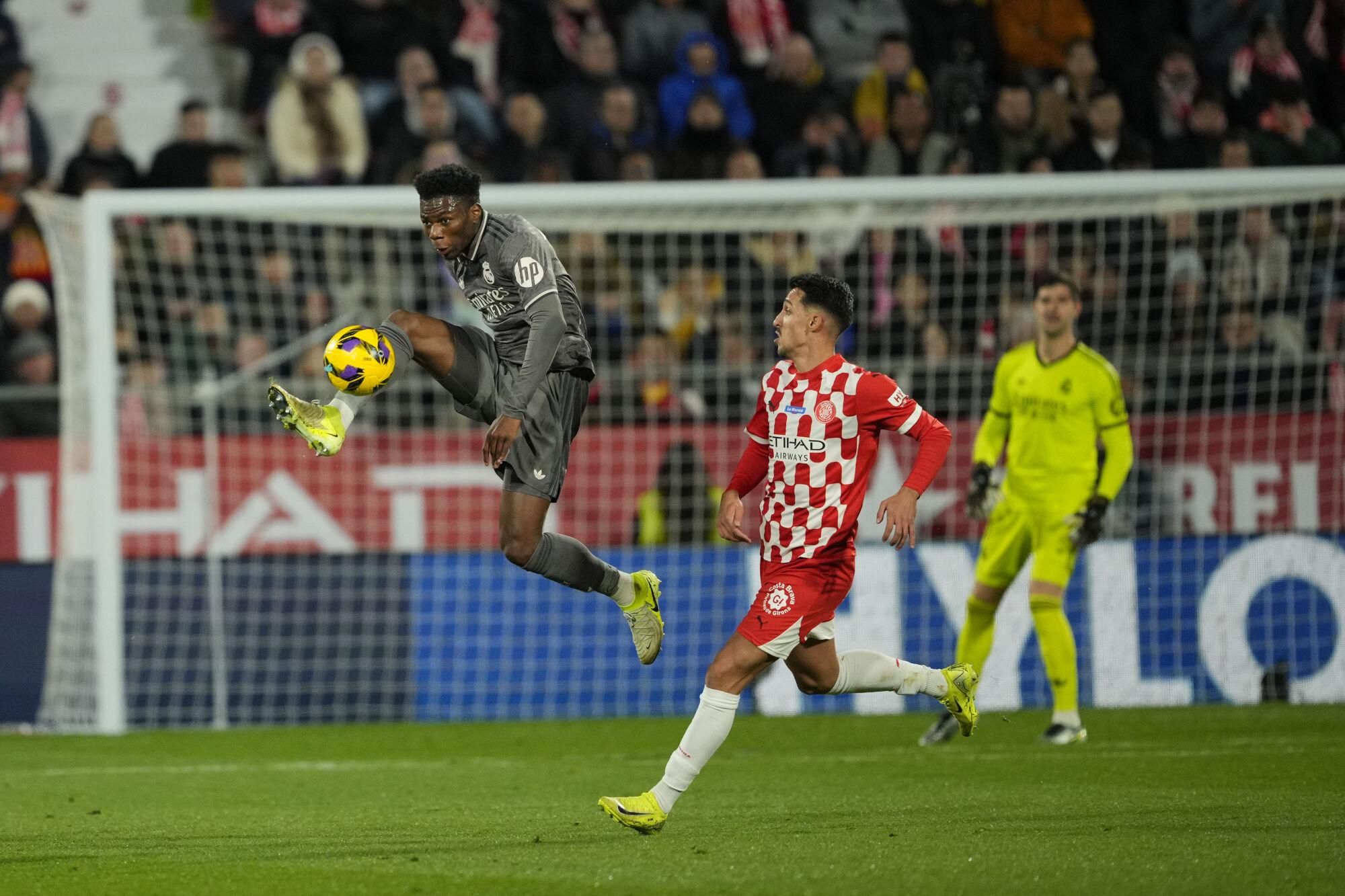 El centrocampista del Real Madrid Aurélien Tchouaméni (i) disputa un balón ante el delantero del Girona Bojan Miovski, durante el partido de la jornada 19 de LaLiga que Girona FC y Real Madrid disputan este sábado en el estadio Montilivi, en Girona. EFE/Alejandro García. (Girona) (Real Madrid)