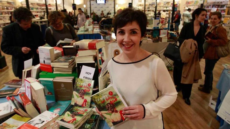 La escritora Eva Fernández, mostrando su libro ayer en la feria de la plaza de Trascorrales.