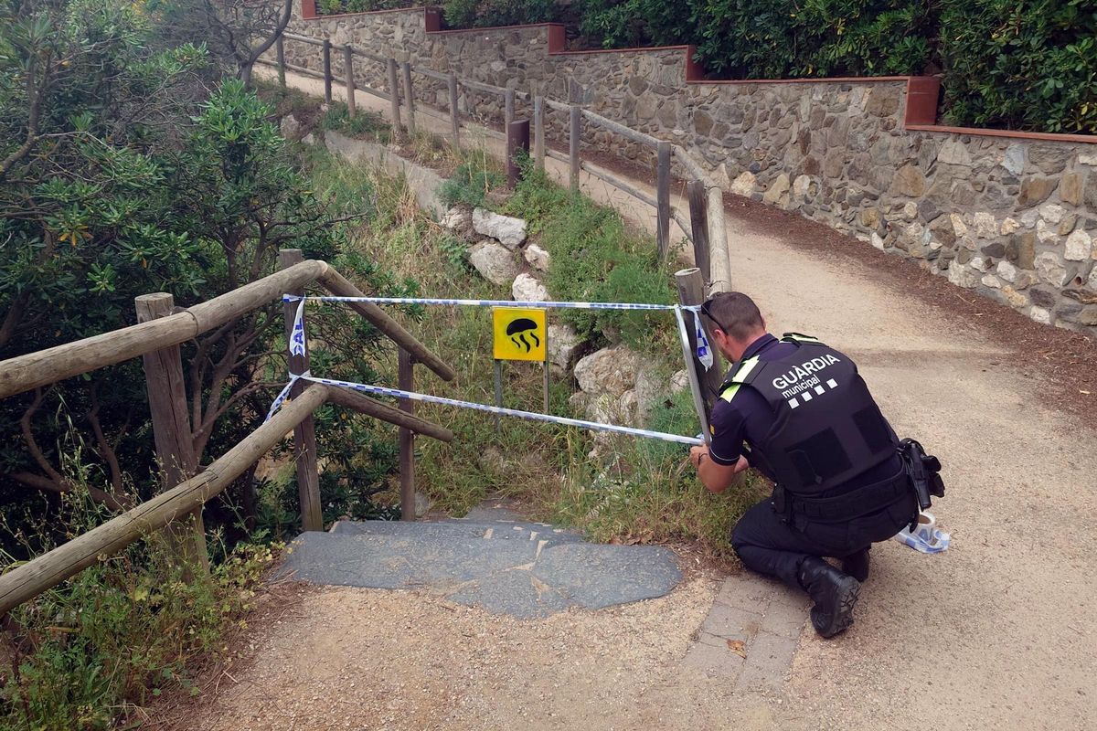 Un dels agents clausurant l'accés a una de les platges del Port de la Selva per precaució, a inicis de juny.
