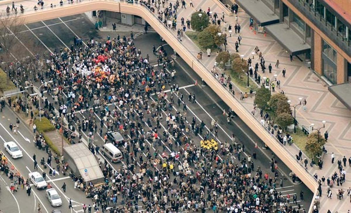 Centenars de persones es reuneixen al carrer després d’evacuar els edificis a causa del terratrèmol, a Sendai, al Japó.