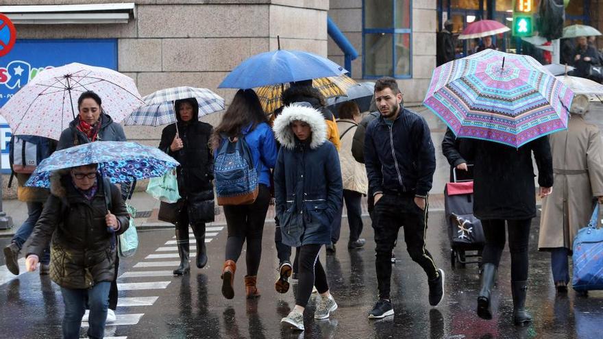 Viandantes se protegen de la lluvia. // Marta G. Brea