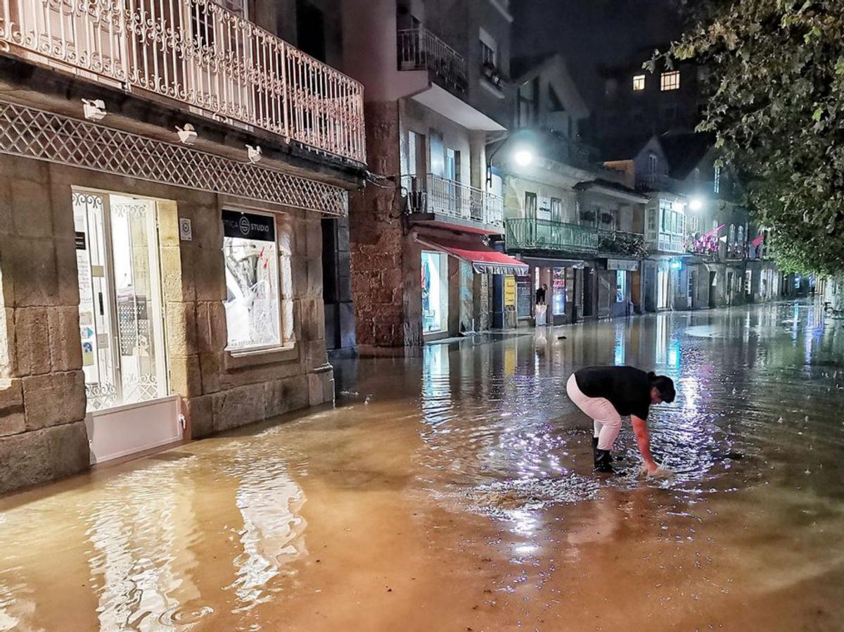 Fuertes lluvias e inundaciones en Cangas. Las intensas lluvias caídas en torno a las nueve de la noche de ayer provocaron las primeras inundaciones del otoño en Cangas, en concreto, en la calle Eugenio Sequeiros, que arrastra este problema desde hace años. Bueu subsanó el suyo con las inundaciones del río Bispo que anegaban el casco urbano; Cangas sigue pendiente de dar solución. | SANTOS ÁLVAREZ