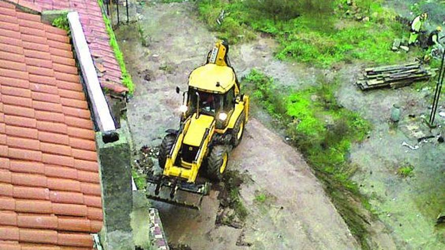 Una excavadora y operarios, trabajando, ayer, en el solar de Ortiz en Candás.