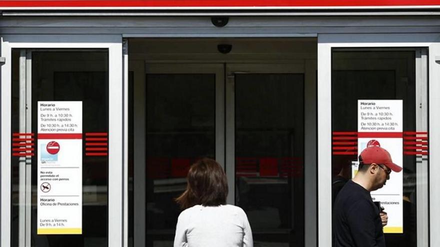 Una mujer, frente a una oficina de empleo.