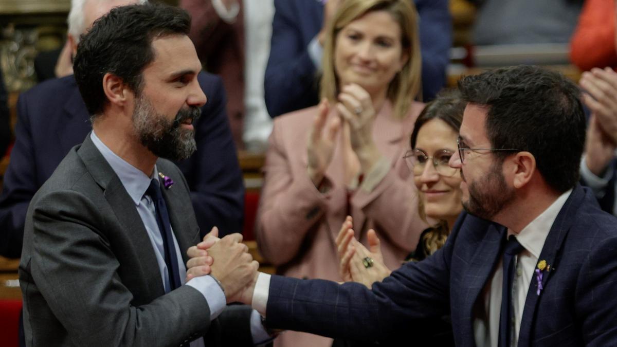 BARCELONA (ESPAÑA), 23/11/2022.-El expresidente del Parlament y actual conseller de Empresa, Roger Torrent (i), felicitado por el presidente de la Generalitat, Pere Aragonès (d) durante el pleno del Parlament este miércoles tras conocerse la noticia de que el Tribunal Superior de Justicia de Cataluña (TSJC) le ha absuelto a él y a los miembros de JxCat y ERC de su Mesa, al concluir que no desobedecieron al Constitucional (TC) al tramitar resoluciones soberanistas en la pasada legislatura.EFE/Quique García  Barcelona [Municipio]