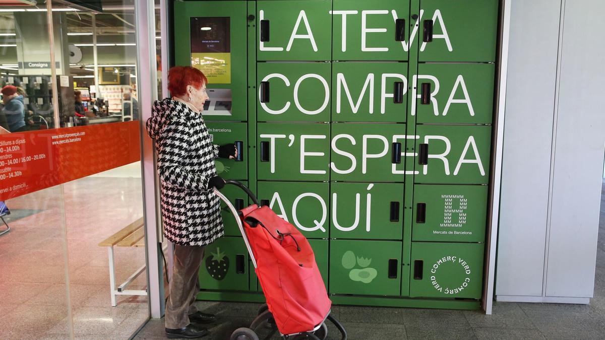 Una mujer usa una de las taquillas refrigeradas en el Mercat de Provençals.