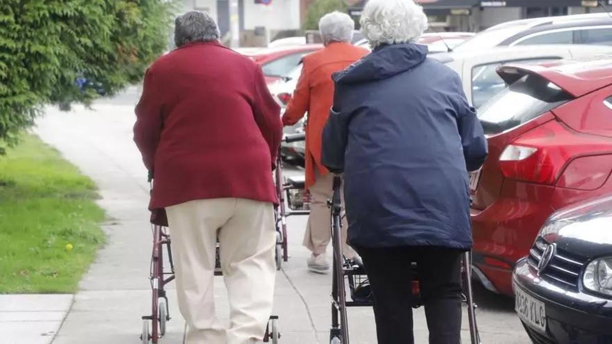 Varias mulleres maiores con problemas de movilidade polas rúas de Santiago