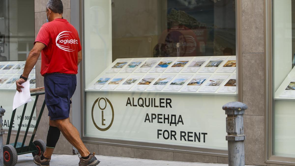 Un trabajador, junto a una inmobiliaria de Alicante.