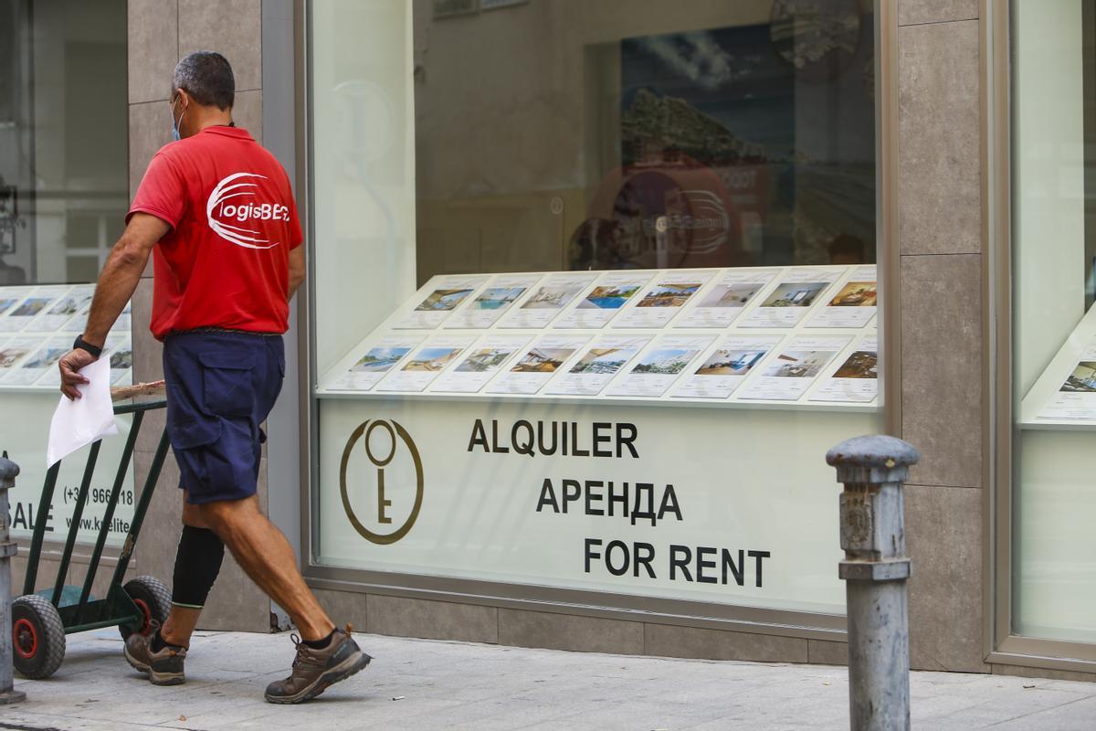 Un trabajador, junto a una inmobiliaria de Alicante.
