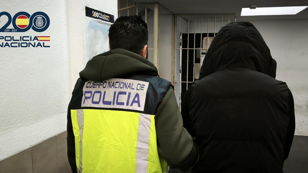 Un policía traslada a uno de los detenidos a los calabozos de la Jefatura de Palma.