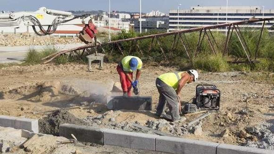 Obreros trabajan en la zona del ofimático que falta por urbanizar.